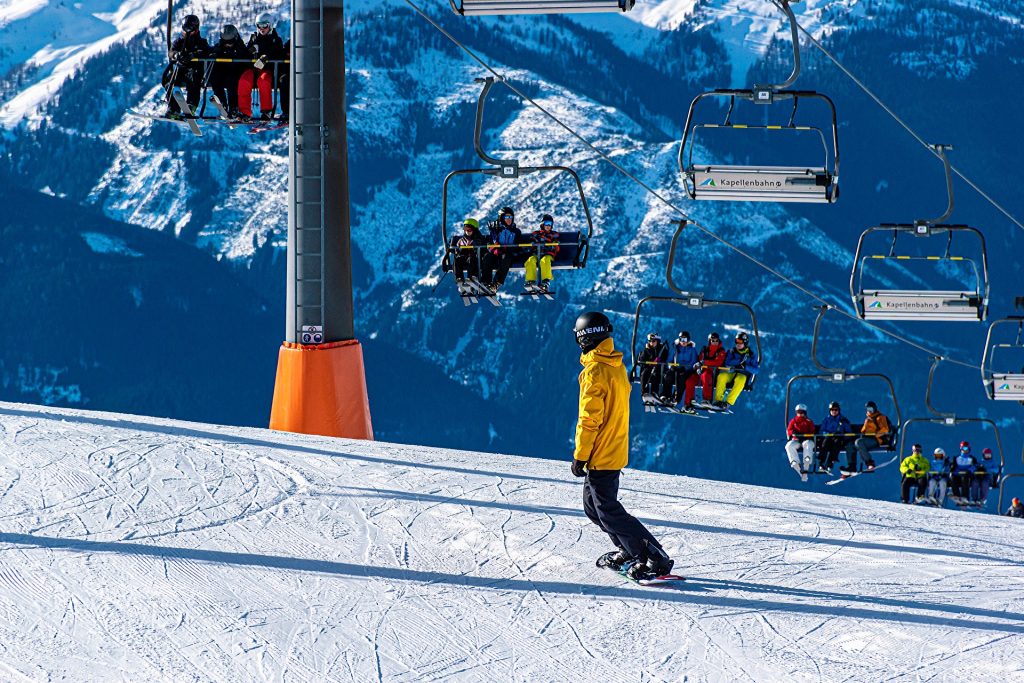 Une personne en snowboard en dessous d'un télésiège dans une station de ski