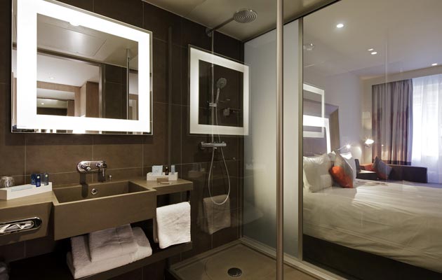 Cloison de verre innovante entre la chambre et la salle de bain avec douche « rainshower » ou bain
